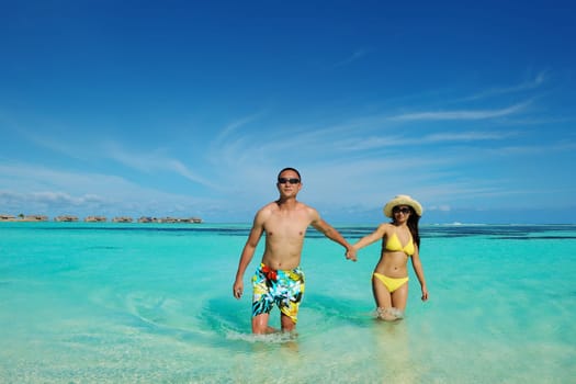 happy young asian couple enjoying summer and have on beautiful white sand beach