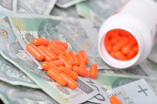 pile of orange pills on banknotes