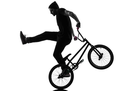 one caucasian man exercising bmx acrobatic figure in silhouette studio isolated on white background