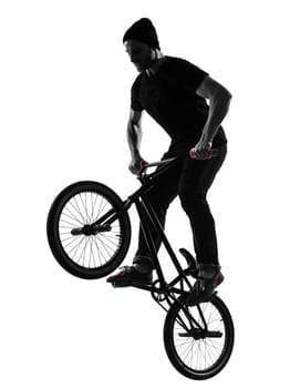 one caucasian man exercising bmx acrobatic figure in silhouette studio isolated on white background