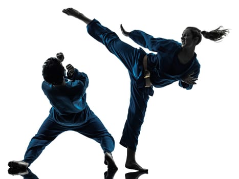 one  man woman couple exercising karate vietvodao martial arts in silhouette studio isolated on white background