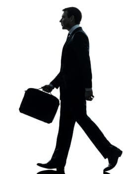 one caucasian businessman walking side view in silhouette studio isolated on white background