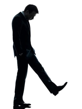one caucasian sad business man  looking down  in silhouette studio isolated on white background