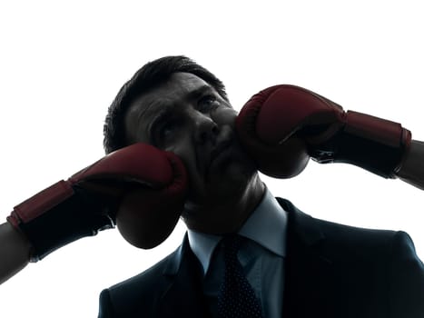 one caucasian businessman punch by boxing gloves  in silhouette studio isolated on white background