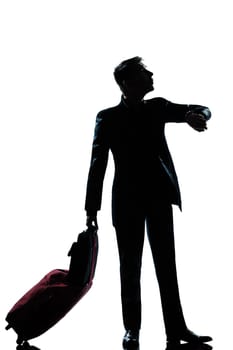 one caucasian  business traveler man checking the time full length silhouette in studio isolated on white background