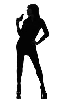 one caucasian sexy detective  woman holding aiming  gun in silhouette studio isolated on white background