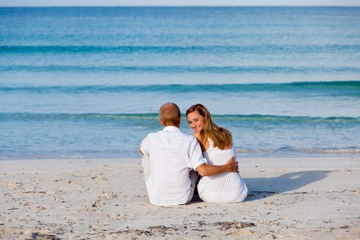 Young happy couple in love having fun on the beach in summer