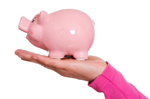Female hand holding a pink porcelain piggy bank