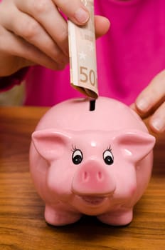 Pink piggy bank and 50 euro bill