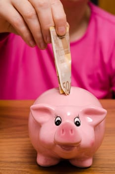 Pink piggy bank with 50 euro bill