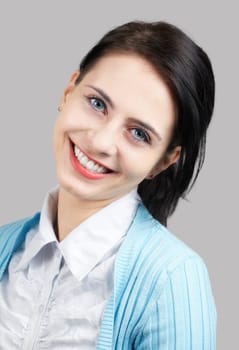 Portrait of a beautiful young woman smiling isolated on grey