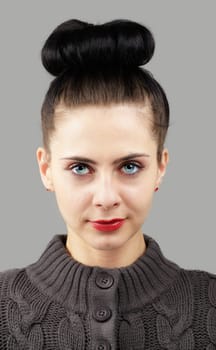 Portrait of a beautiful young woman with blue eyes isolated on grey