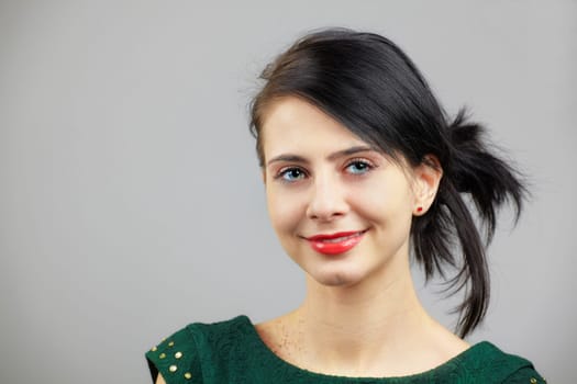 Portrait of a beautiful young woman isolated on grey.