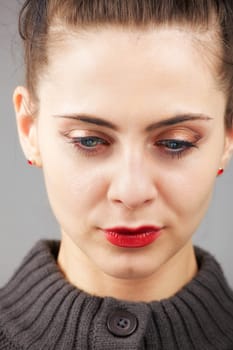 Portrait of a beautiful young woman with blue eyes isolated on grey