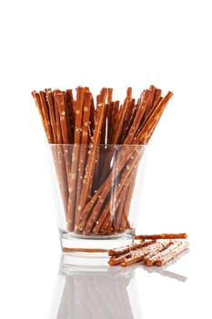 Pretzel sticks in a glass on white background