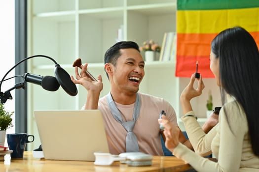 Joyful Asian gay man and friend recording podcast from home studio. Radio, podcasts and blogging concept.