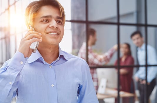 young man looking away while talking on the phone.