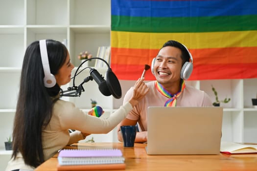 Positive gay male beauty blogger and his friend filming review of new cosmetics for their channel.