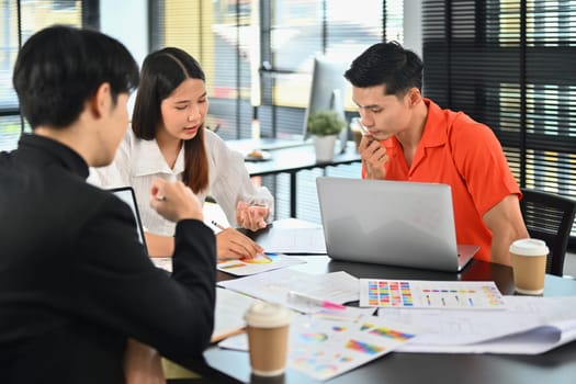 Team of interior designer brainstorming together over joint building project in modern office.