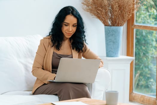 African-American woman using laptop computer for crucial work on internet. Secretary or online content writing working at home.