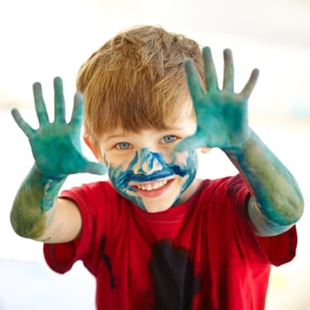 Portrait, hands and a boy painting in studio on white background for creative expression or education at school. Art, paint and smile with an excited young child looking happy with messy creativity.