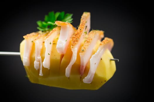 Raw potatoes prepared for baking, with lard isolated on black background