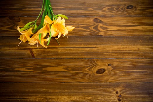 bouquet of beautiful yellow lilies on a dark wooden table