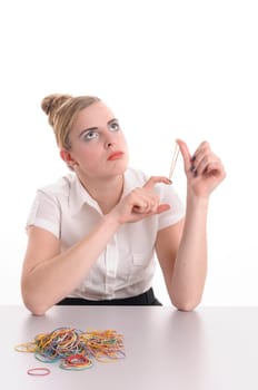 Young woman with blond hair wearing a business suit and has bored in the office, she plays with a rubber band, isolated against white background.