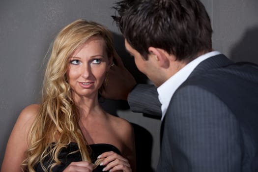 Man flirting with a woman standing at the wall