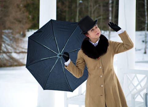 Woman with black umbrella feeling winter wind flow