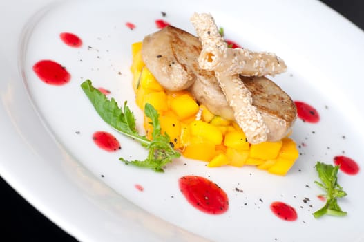 Pan seared foie gras on ripe mango and pomegranate reduction