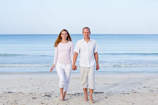 Young happy couple in love having fun on the beach in summer