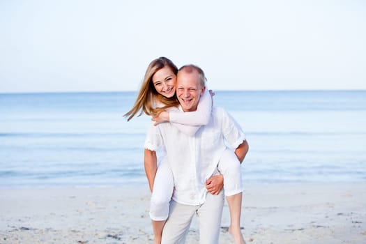 Young happy couple in love having fun on the beach in summer