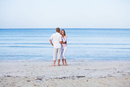 Young happy couple in love having fun on the beach in summer