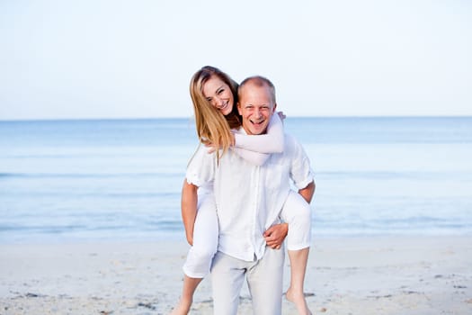 Young happy couple in love having fun on the beach in summer