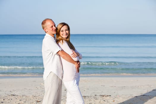 Young happy couple in love having fun on the beach in summer