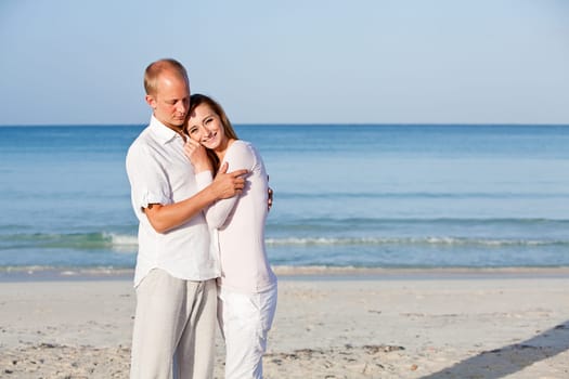 Young happy couple in love having fun on the beach in summer