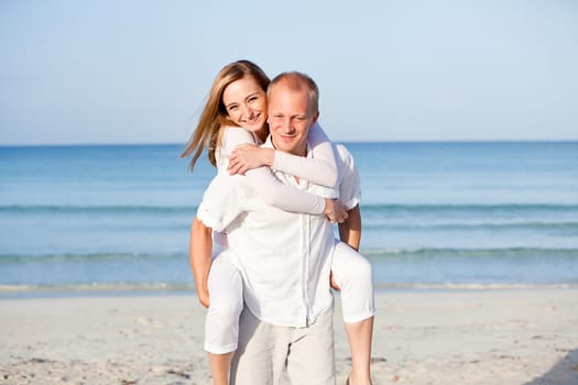 Young happy couple in love having fun on the beach in summer