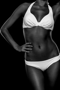 Young woman with white bikini against black background