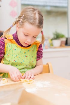 Little girl baking cookies in the kitchen