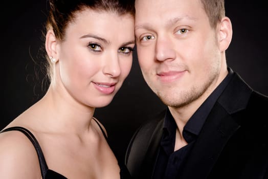 Studio shot of a young couple against a black background