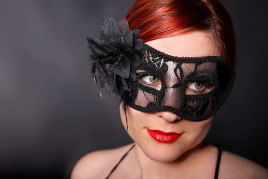 Young woman with black carnival mask