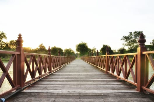 wooden bridge across the lake in the evening