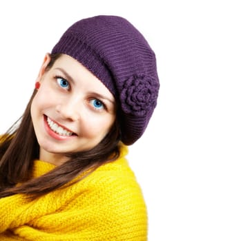 Portrait of a beautiful young woman with yellow scarf and purple hat over white.