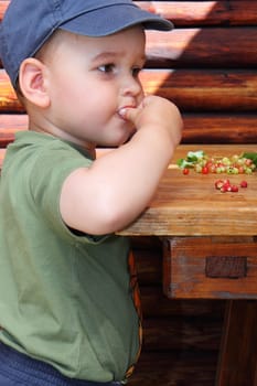 little boy eat forest strawberries and red currants