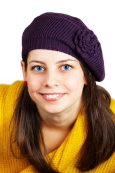 Portrait of a beautiful teenage girl with yellow scarf and purple hat over white.