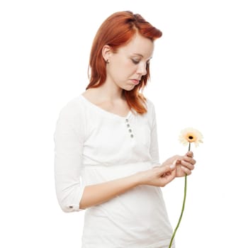 young beautiful red haired girl is playing he loves me not in front of white background