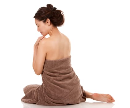 beautiful asian brunette wearing brown towel on white background