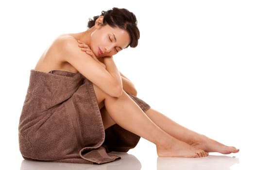 beautiful asian brunette wearing brown towel on white background