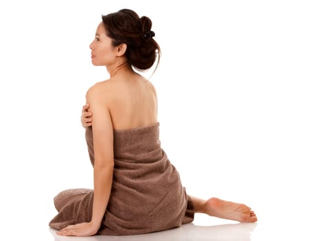beautiful asian brunette wearing brown towel on white background